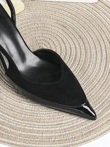 Nahaufnahme der schwarzen spitzen Stöckelschuhe mit matten und glänzenden Texturen