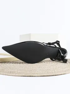 Detaillierte Makroansicht der schwarzen spitzen High-Heel-Sohle und des Slingback-Riemens