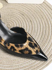 Nahaufnahme eleganter High Heels mit Leopardenmuster und spitzer Lacklederkappe