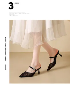 Detail view of elegant black mesh high-heeled mules with crystal buckle worn by model
