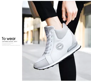 White women's hidden wedge high-top sneaker detail worn in a bright outdoor street setting