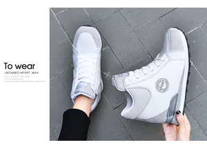 Detailed view of women's fashion high-top sneakers in white and gray featuring a hidden wedge heel