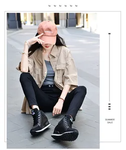 Fashionable black hidden wedge canvas sneakers worn by a model in a stylish street setting