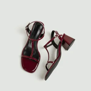 Bordeauxrode lakleren sandalen met T-bandjes, blokhakken en verstelbare enkelgespen.