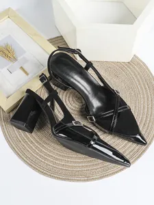 Dettaglio di décolleté slingback nere a punta con cuciture in camoscio e vernice