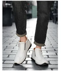 Close-up detail view of white high-top leather shoes with side zipper design