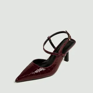 Dettaglio macro del motivo coccodrillo rosso vino sui sandali slingback a punta