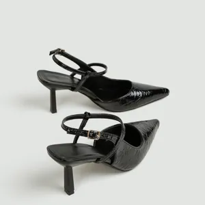 Primo piano di scarpe slingback nere a punta con trama stropicciata e tacco 7cm