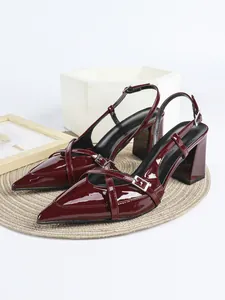 Dettaglio scarpe bordeaux in vernice con punta, tacco largo e cinturini incrociati