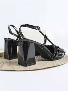 Vista dettagliata di décolleté slingback in vernice nera con un tacco largo a blocco