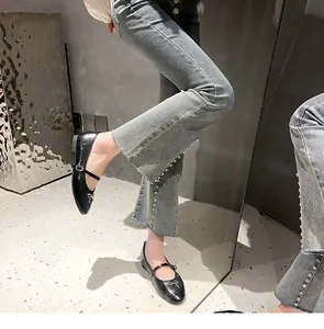 Detailopname van zwarte Mary Jane ballerina's met strik en jeans met parels