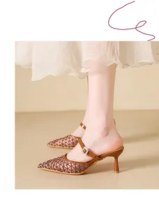 Detailed view of women's vintage brown mesh high-heeled mules worn with a dress.