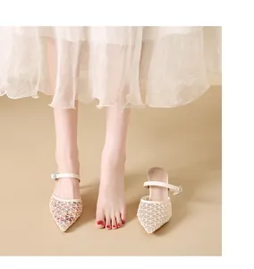 Detailed view of white mesh pointed-toe high heel mules on a model's foot
