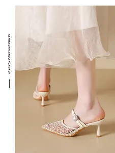 Close-up detail of vintage beige mesh pointed-toe mule heels with crystal buckle