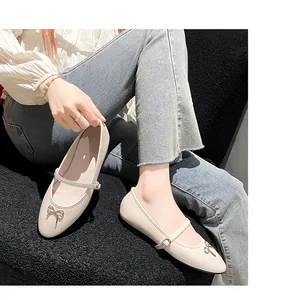 Detailopname van beige Franse Mary Jane platte schoenen met strikje en gespbandje
