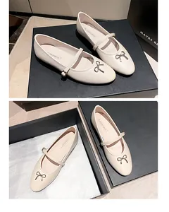 Gedetailleerde weergave van gebroken witte Mary Jane flats met strik in doos.