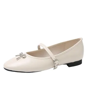 Elegante beige Mary Jane-flats met metalen strikdetail en verstelbaar gespbandje.
