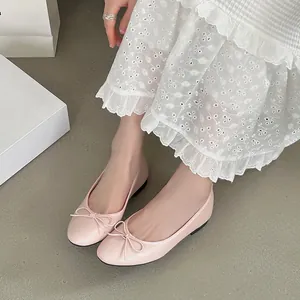 Elegant light pink ballet flats featuring cute bow detail and soft round toe design