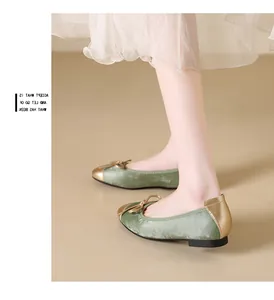 Dettaglio di ballerine in velluto verde con punta dorata e fiocco decorativo
