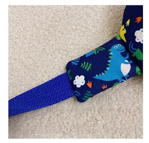 Detaillierte Nahaufnahme der Nähte an einer blauen Kinder-Brusttasche mit Dinosaurier-Print