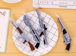 Gros plan de stylos à bille originaux en forme de pistolet avec aimants sur une assiette