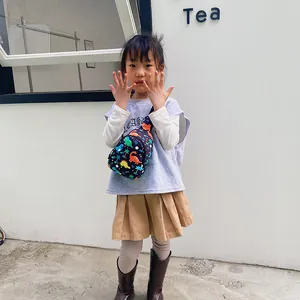 Niedliche Kinder Brusttasche mit bunten Dinosaurier Prints, getragen von Mädchen