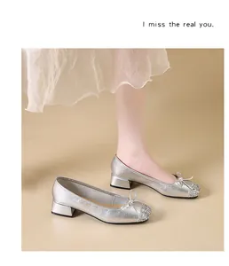 Elegant silver Mary Jane shoes with bow detail and glitter toe on a model.