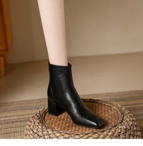 Detailed side view of a black square-toe leather ankle boot with stylish chunky heel.