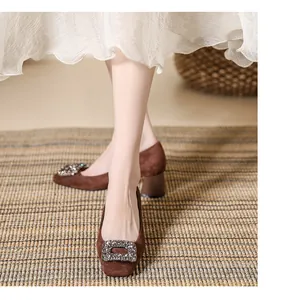 Detail view of brown suede square toe pumps with elegant sparkling rhinestone buckle detail