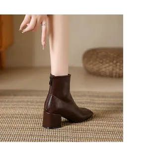 Rear view of brown square-toe leather ankle boot featuring a chunky heel and back zipper.