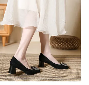 Elegant black suede block heel pumps with sparkling rhinestone buckle detail.