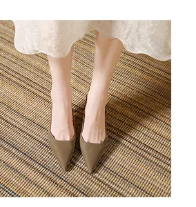 Κομψές λαδί γόβες slingback με μυτερή μύτη πάνω σε ένα κομψό ανάγλυφο χαλί.
