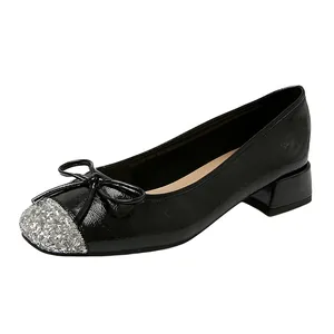 Elegant black low heel pumps with silver glitter toe cap and bow detail, 45-degree angle view.