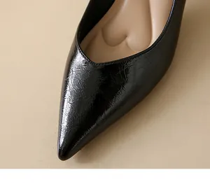 Macro view of black crinkled patent leather pumps featuring heart-cushioned insole