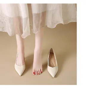Detail view of elegant cream pointed-toe high heels with slim heels and soft leather finish