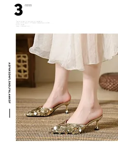 Elegant gold sequined pointed-toe mules with stylish kitten heels worn by a model