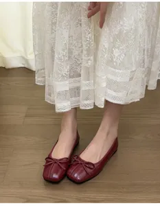 Nahaufnahme von weinroten Ballerinas mit quadratischer Zehenpartie und Schleifendetail