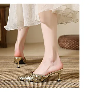 Close-up of elegant gold sequined pointed-toe kitten heel mules for women