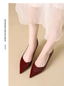 Detailed macro shot of elegant burgundy pointed-toe stiletto pumps worn by an Asian model