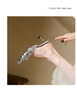 Elegant silver sequined pointed-toe mules with kitten heel, detail view of sparkling finish.