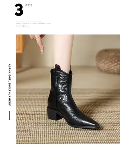 Détail de bottines cowboy vintage en cuir souple noir avec bout pointu et découpe en V
