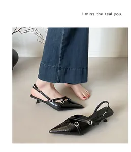 Detailweergave van elegante zwarte slingback pumps met spitse neus en gespbandjes