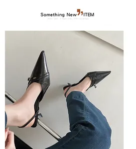 Gedetailleerde weergave van zwarte puntige slingback kitten heels aan de voeten