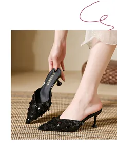 Close-up of black sequined pointed-toe kitten heel mules with stylish kitten heels