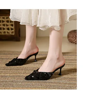 Close-up of black sequined pointed-toe kitten heel mules for stylish evening wear