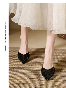 Close-up view of elegant black sequined pointed-toe mules featuring a stylish kitten heel