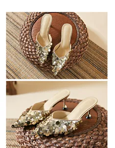 Close-up of gold sequined pointed-toe kitten heel mules on a textured woven base.