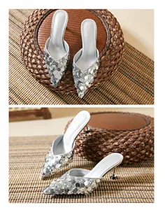 Exquisite silver sequined pointed-toe mules shown from top and side view angles.