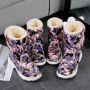 Close-up of kids' pink camouflage snow boots featuring thick white soles and warm faux fur lining