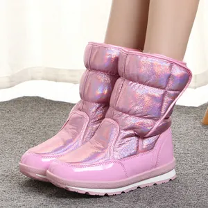 Side view of children wearing pink metallic waterproof snow boots on a soft carpet